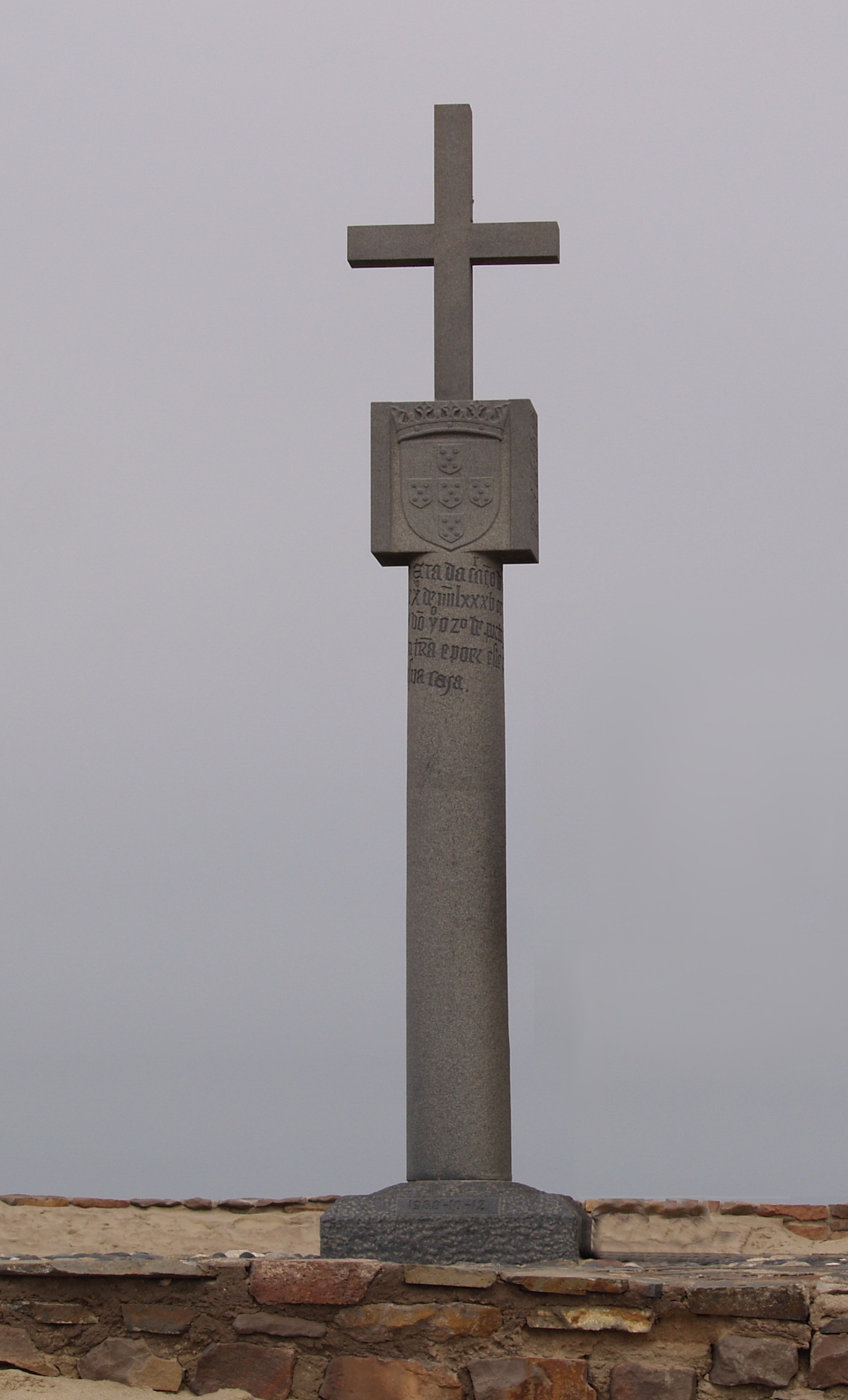 A stone monument with a cross on top. 