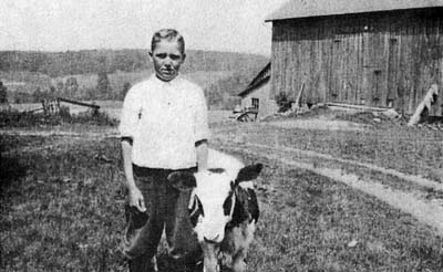 Picture of an orphan child on a barn with his goat.