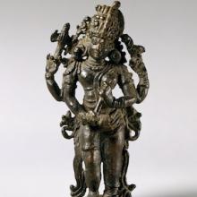 Bronze sculpture of Shiva standing with a head dress. 